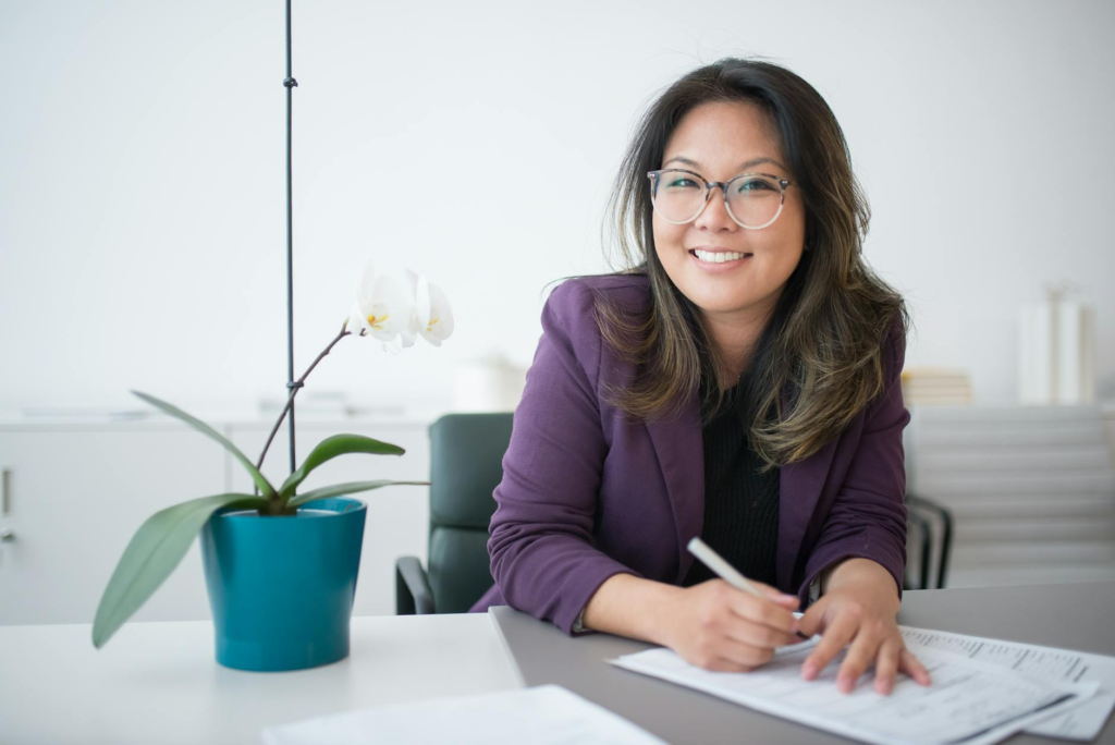 a woman sitting on a table with potted plant