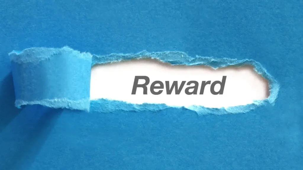 A blue paper ripped in a curl to reveal the word Reward, indicating a prize or award for student good behavior