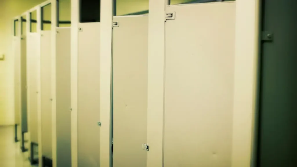 A row of bathroom stalls at a middle school, showing student independence with bathroom procedures