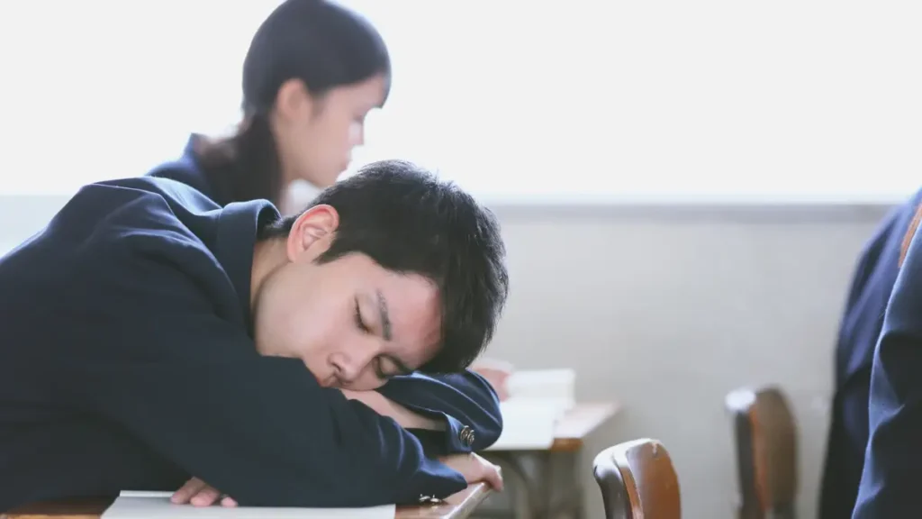A middle school student rests his head on his desk and closes his eyes, showing a disengaged student in need of a brain break.