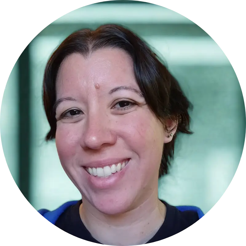 A headshot of Tori, classroom management coach and former classroom teacher, in front of a blurry green background. Tori has short dark hair and a sincere smile. Her eyes are bright and eager to help teachers get control of their classrooms.