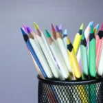 Assorted sharpened colored pencils rest point-up in a cup