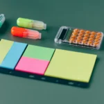 Assorted office supplies including sticky notes and highlighters on a green background.