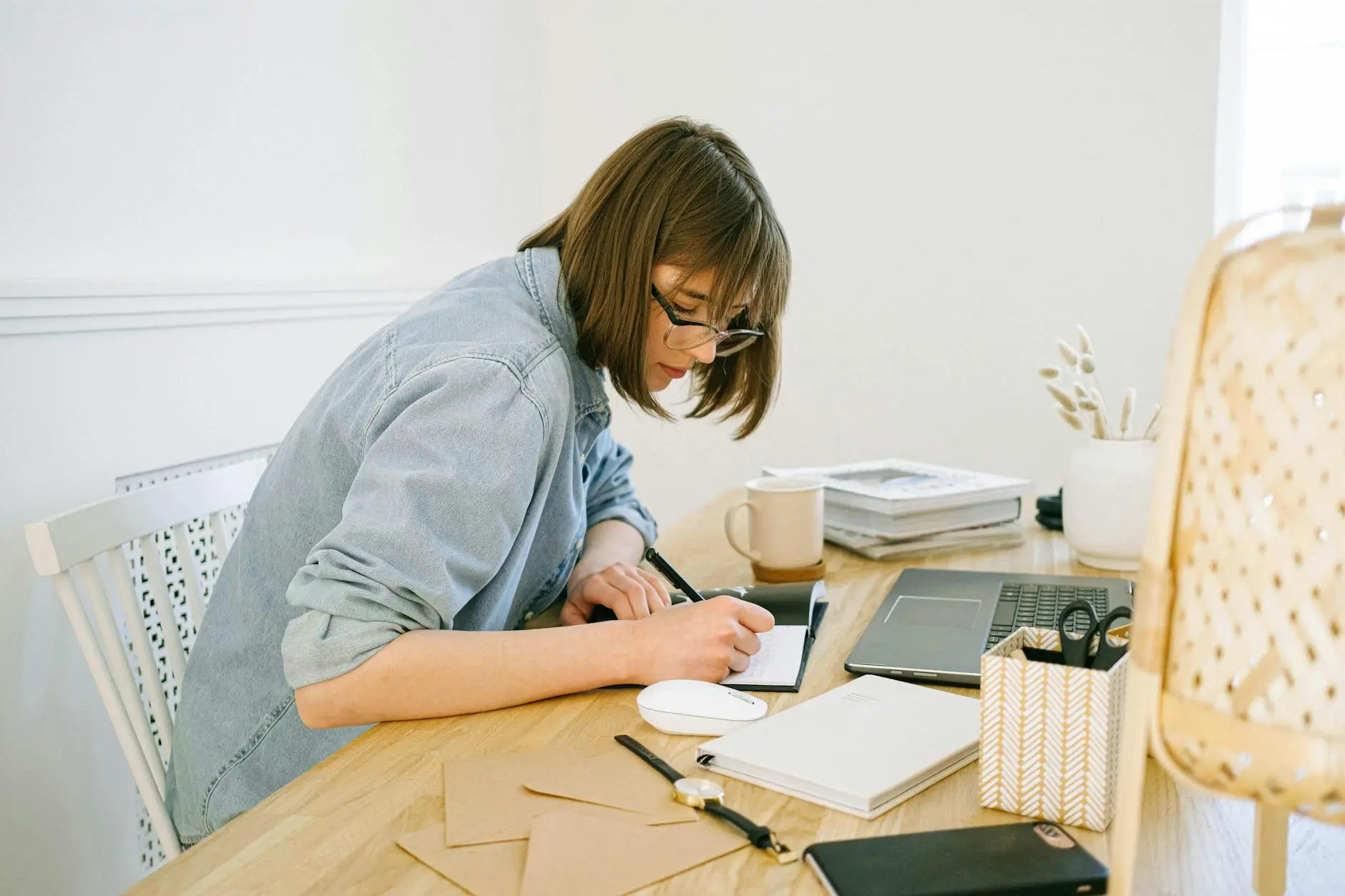 A teacher sits at a desk filling out paperwork. The desk, walls, and papers around her are all light and bright, representing confidence and positivity now that parent-teacher conferences are over