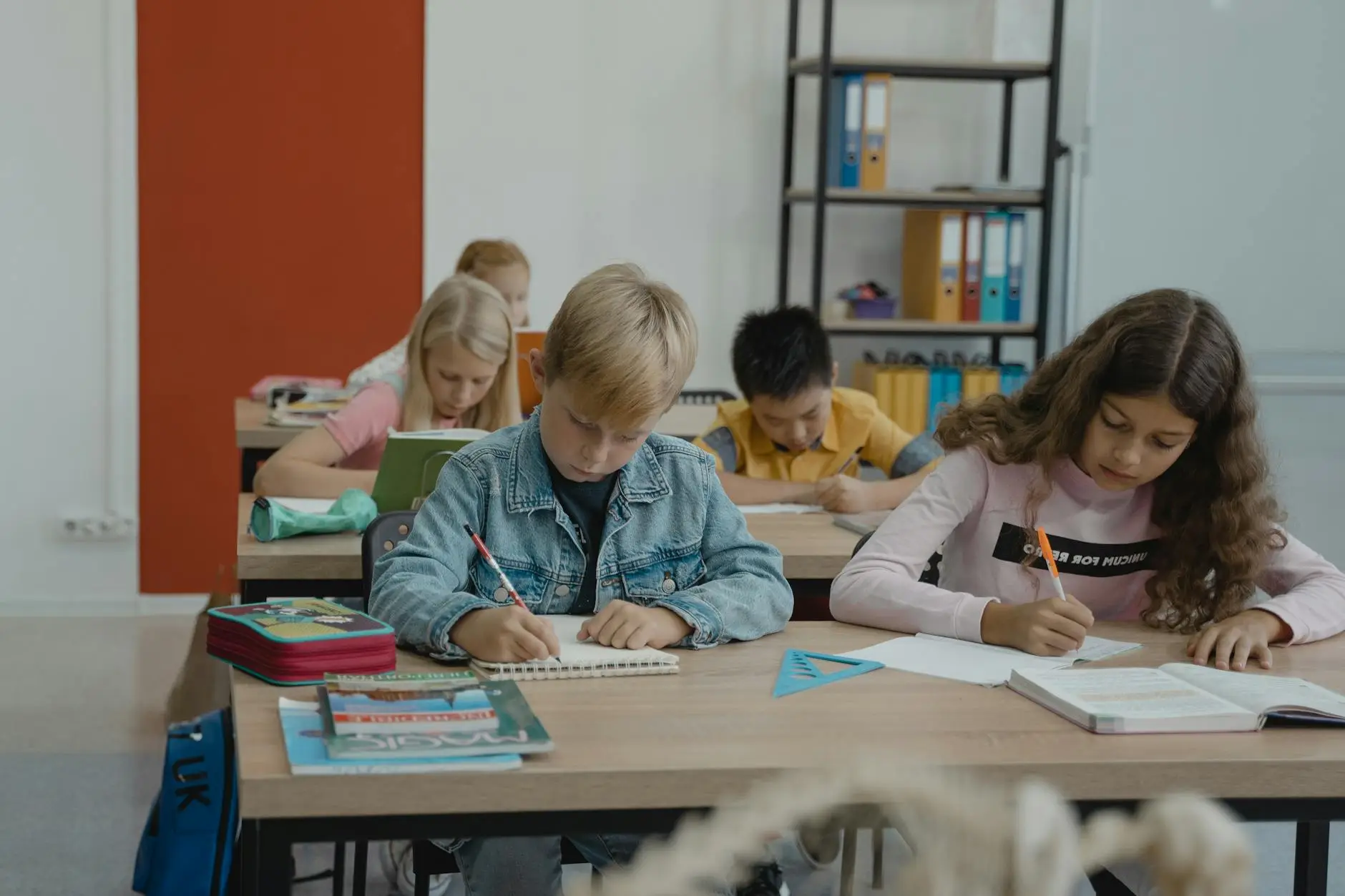 Rows of students sit side by side, writing diligently. Their attention is focused on their papers, giving their teachers valuable beginning-of-year information through their written responses.