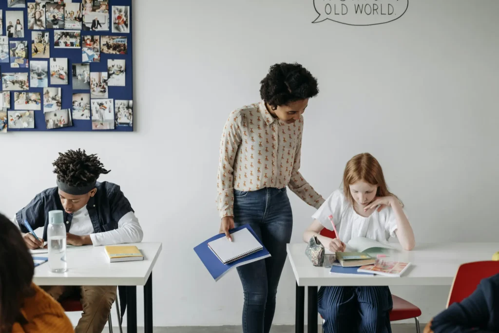 A teacher guides students during a classroom activity, fostering engaging learning.