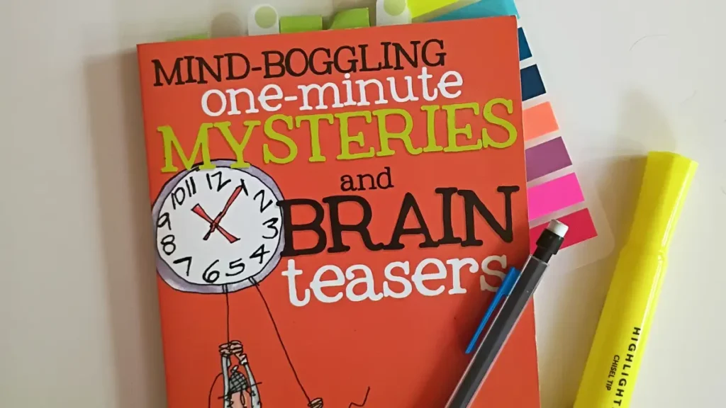 The cover of the book Mind-Boggling One-Minute Mysteries and Brain Teasers with sticky flags, a highlighter,