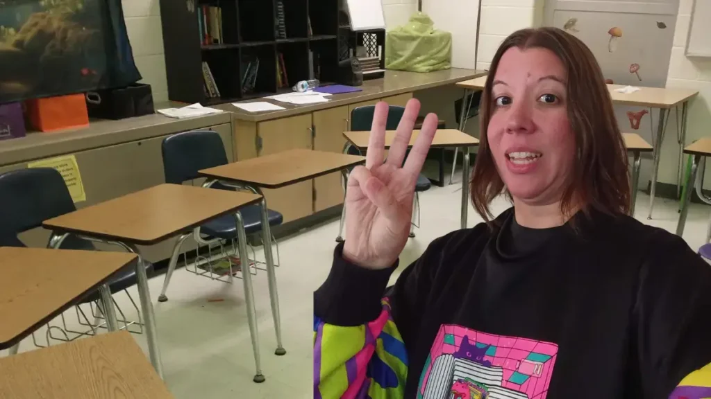A photo of Tori holding up three fingers demonstrating a quiet signal to help teachers stop screaming at students in the classroom